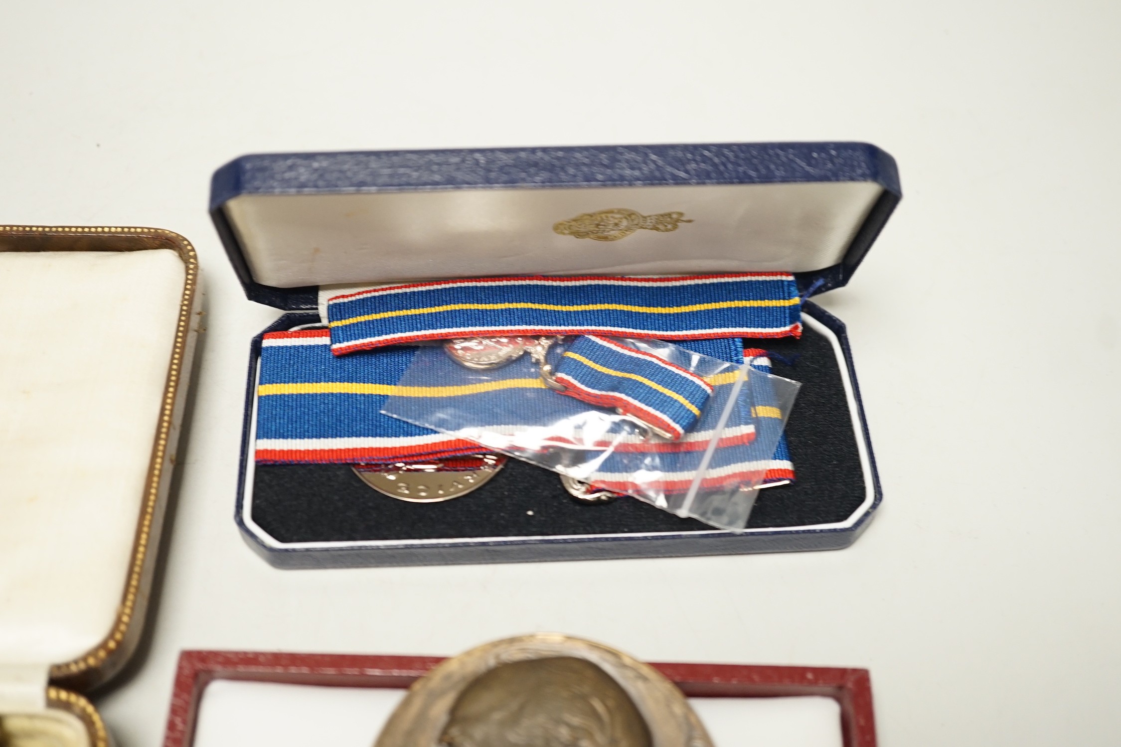 Two powder flasks and militaria including cap badges and miniature medals